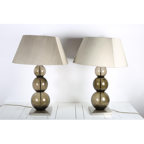 94 - A PAIR OF CHROME AND SMOKED GLASS TABLE LAMPS each with a knopped column above a square chrome base ... 