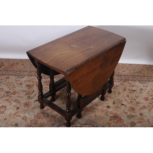 125 - A 19TH CENTURY WALNUT DROP LEAF TABLE the oval hinged top raised on baluster legs joined by cross st... 