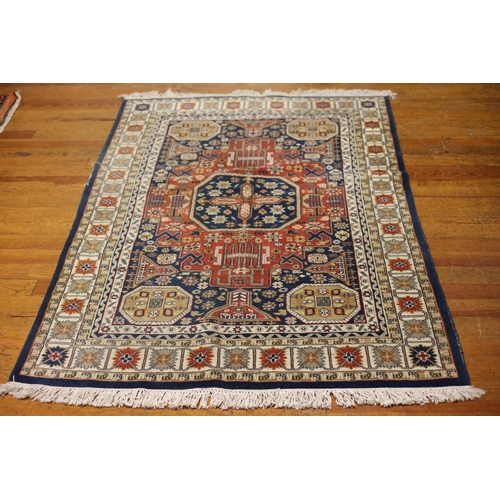126 - A TURKISH TRIBAL RUG the indigo gold and beige ground with central panel filled with stylized flower... 