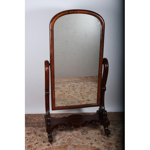 30 - A 19TH CENTURY MAHOGANY CHEVAL MIRROR the rectangular arched plate within a moulded frame raised on ... 