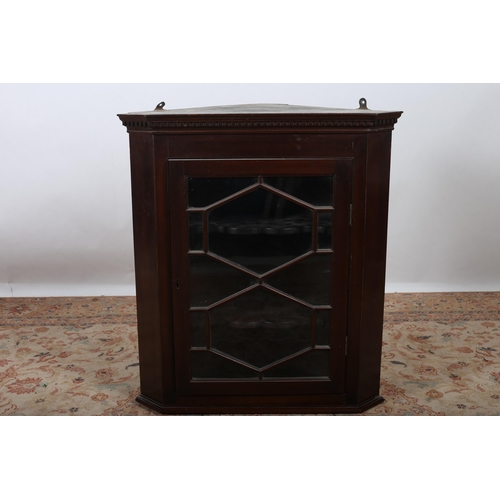 609 - A 19TH CENTURY MAHOGANY GLAZED DOOR HANGING CORNER CABINET the dentil moulded cornice above an astra... 