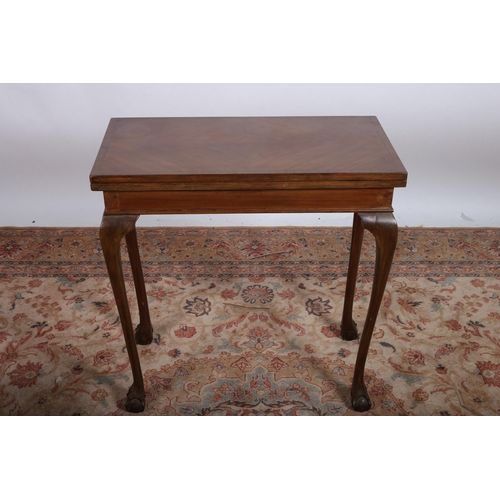 611 - A VINTAGE MAHOGANY CROSSBANDED FOLDOVER CARD TABLE the rectangular hinged top containing a baise lin... 