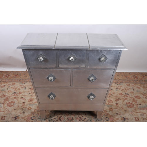 98 - A WHITE METAL CHEST of rectangular tapering form the shaped top above three short, two long and one ... 