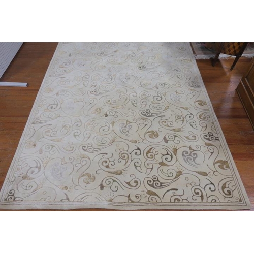 23 - A WOOL RUG the beige and gold ground with central panel filled with C-scrolls within a conforming bo... 