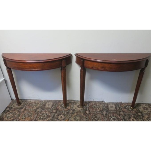 789 - A PAIR OF CONTINENTAL MAHOGANY CONSOLE TABLES each of demi lune outline the shaped top above a mould... 