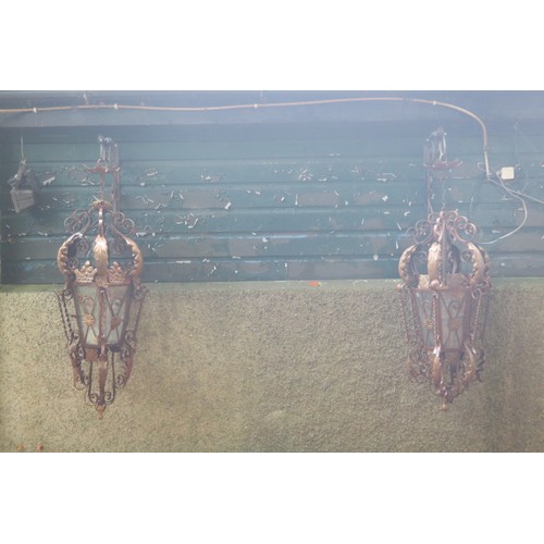 796 - A PAIR OF WROUGHT IRON AND GLAZED SINGLE LIGHT WALL MOUNTED LANTERNS with foliate flowerhead and scr... 