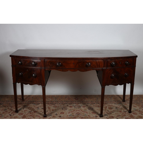 42 - A GEORGIAN MAHOGANY SIDEBOARD of demi lune outline the shaped top above a frieze drawer flanked by t... 