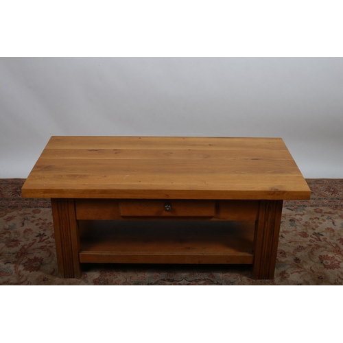 486 - A CONTEMPORARY OAK COFFEE TABLE of rectangular outline the shaped top with frieze drawer on reeded m... 