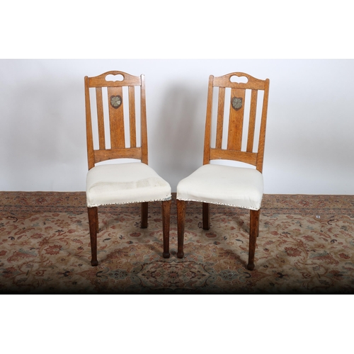 699 - A PAIR OF ARTS AND CRAFTS OAK SIDE CHAIRS bears stamp J.C. each with a pierced shaped top rail above... 