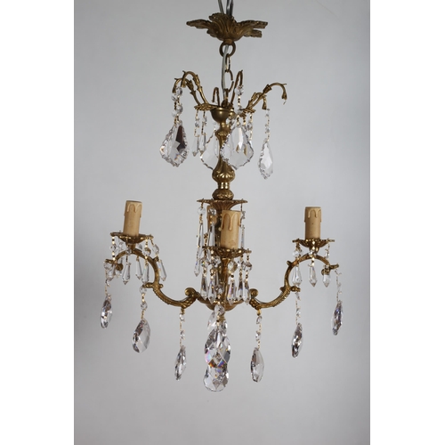 825 - A CONTINENTAL GILT BRASS AND CUT GLASS FOUR BRANCH CHANDELIER hung with faceted pendants 
63cm drop ... 