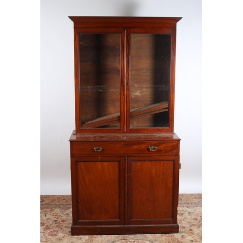 21 - A VINTAGE MAHOGANY BOOKCASE the moulded cornice above a pair of glazed doors containing adjustable s... 
