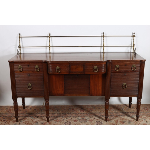 25 - A GEORGIAN MAHOGANY SIDEBOARD of breakfront outline the shaped top with brass gallery above three fr... 