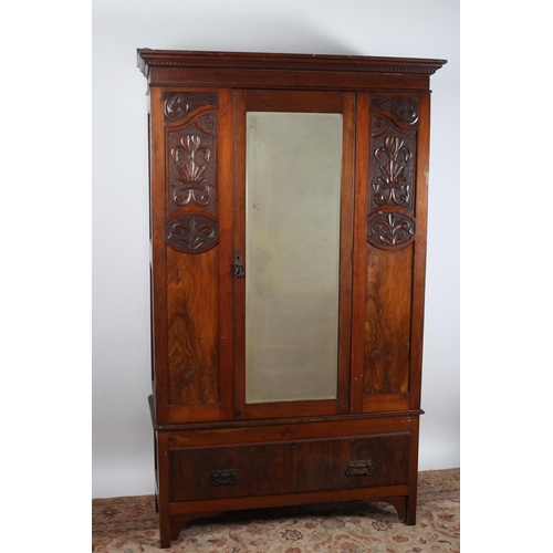 39 - A VINTAGE CARVED MAHOGANY AND WALNUT WARDROBE the dentil moulded cornice above a bevelled glass mirr... 
