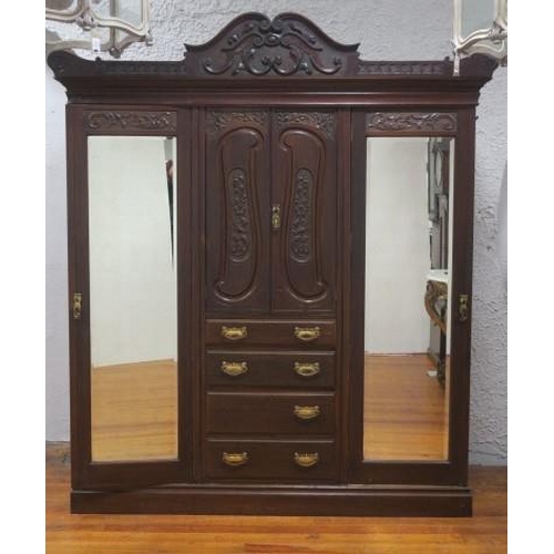 48 - A VINTAGE CARVED MAHOGANY COMBINATION WARDROBE the rectangular arched cornice above a carved panel d... 