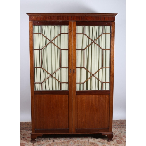 53 - A VINTAGE MAHOGANY CUPBOARD the moulded cornice above a pair of astragal glazed doors containing she... 