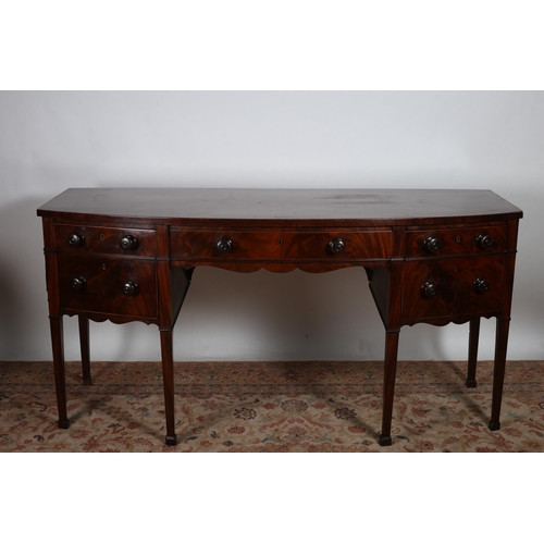 80 - A GEORGIAN MAHOGANY SIDEBOARD of demi lune outline the shaped top above a frieze drawer flanked by t... 