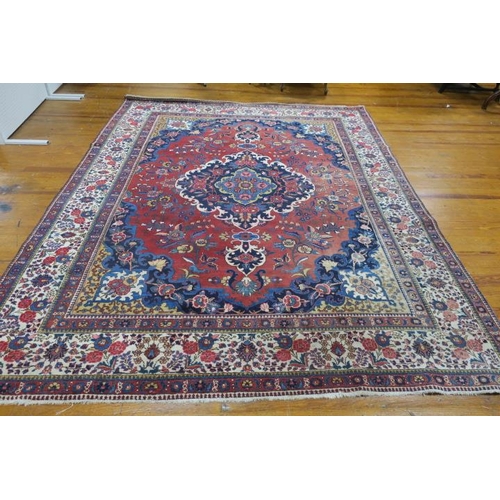 248 - AN TABRIZ WOOL RUG the wine, indigo and beige ground with central panel filled with stylised flowerh... 