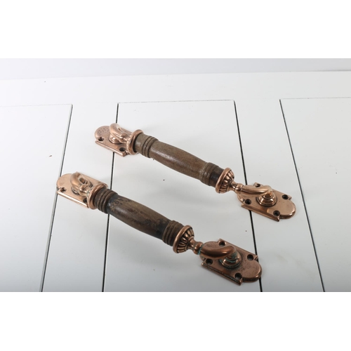 814 - A PAIR OF VINTAGE HARDWOOD AND COPPER DOOR PULLS each with a rectangular arched back plate and turne... 