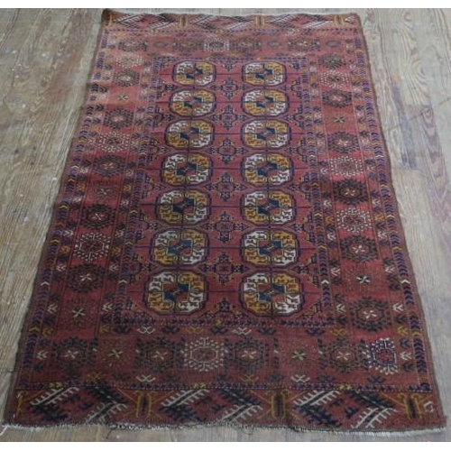 817 - AN ORIENTAL WOOL RUG the light rust ground with central panel containing serrated panels filled with... 