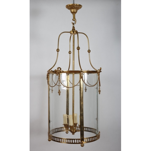 180 - A GILT BRASS AND GLAZED FOUR LIGHT HALL LANTERN of circular form hung with ribbon tied swags 
39cm (... 