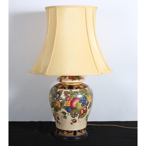 235 - A CONTINENTAL CHINA TABLE LAMP of baluster outline the cream ground decorated with fruit and foliage... 