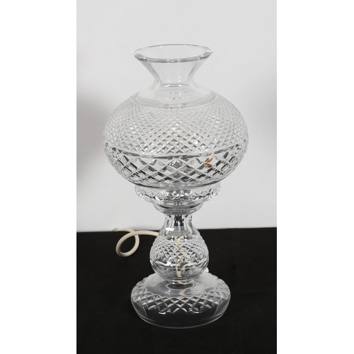 63 - A WATERFORD CUT GLASS TABLE LAMP of baluster outline the shaped bowl above a baluster column on a ci... 