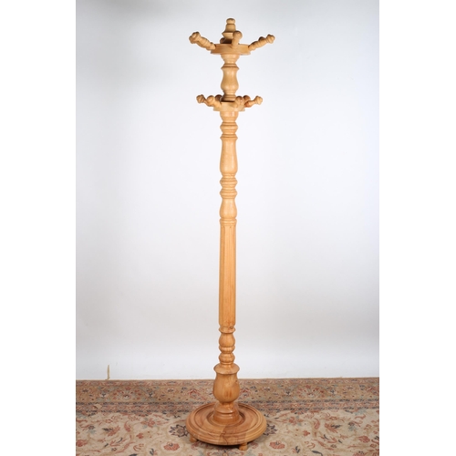 762 - A PINE TWO TIER HAT AND COAT STAND with turned hooks on a balustered and reeded column above a circu... 