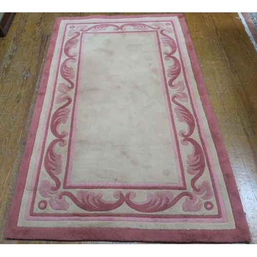 173 - A V'SOSKE JOYCE WOOL RUG the light pink and dark pink ground with central panel within a stylised fo... 