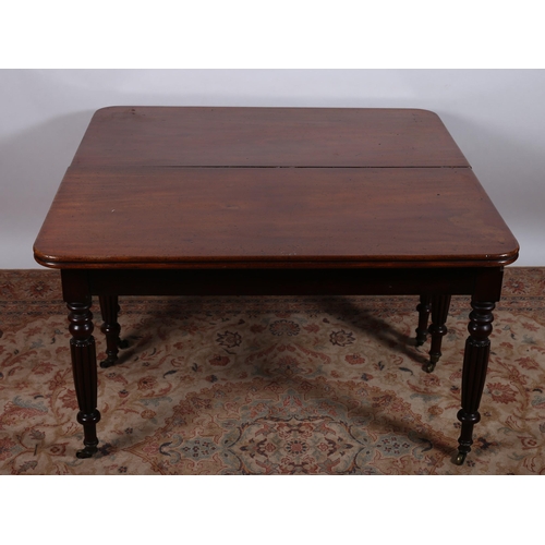 4 - A GEORGIAN MAHOGANY DINING TABLE of rectangular outline with rounded corners and reeded rim raised o... 
