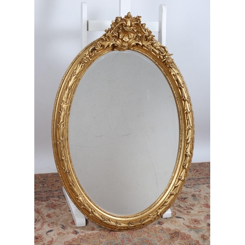 559 - A CONTINENTAL GILT FRAME MIRROR the oval bevelled glass plate within a foliate moulded frame with sh... 