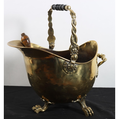 569 - A 19TH CENTURY BRASS SWING HANDLE FUEL BIN with ebonised handle raised on claw feet with shovel
42cm... 