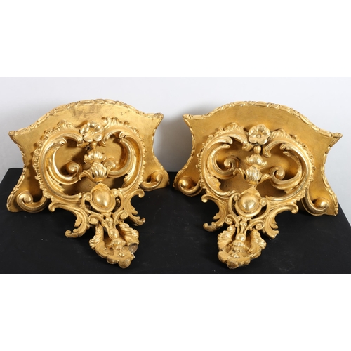 572 - A PAIR OF 19TH CENTURY GILTWOOD AND GESSO WALL BRACKETS each with a serpentine shelf above a C-scrol... 