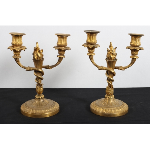 573 - A PAIR OF 19TH CENTURY CONTINENTAL GILT BRASS TWO BRANCH CANDELABRA each with a leaf capped flame co... 