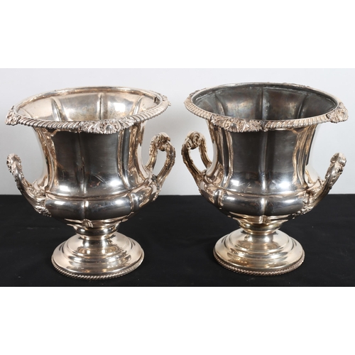 585 - A PAIR OF LATE 19TH CENTURY SILVER PLATED WINE COOLERS each of urn form with foliate scroll handles ... 