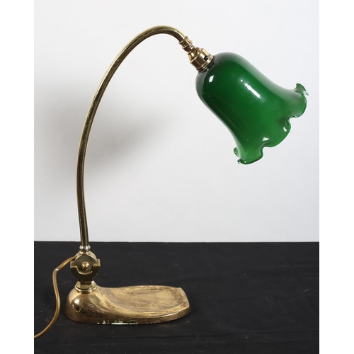 586 - A VINTAGE BRASS READING LAMP the adjustable arm with green glass and opaline glass shade raised on a... 