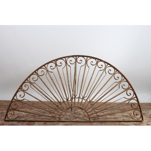 749 - A 19TH CENTURY WROUGHT IRON FAN LIGHT of demi lune outline the shaped frame with C-scrolls and cylin... 