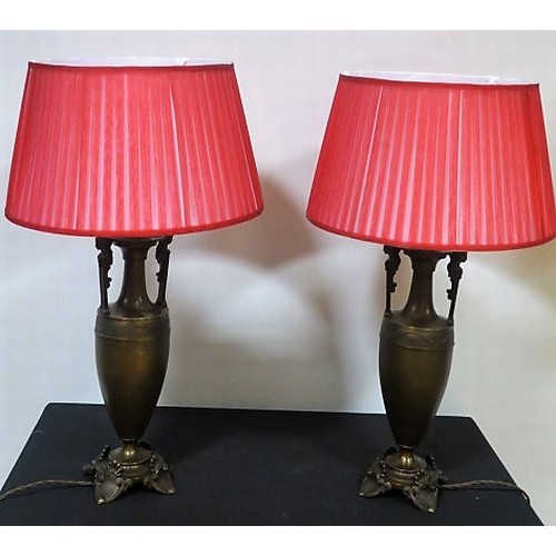 99 - A PAIR OF BRONZED GRECIAN TABLE LAMPS each of urn form with figural mask handles on a circular sprea... 