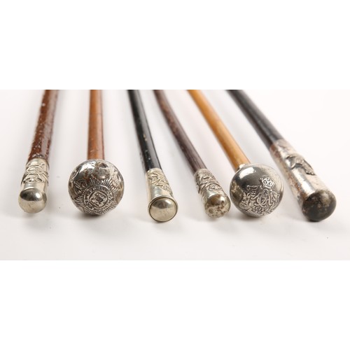 221 - A collection of six regimental swagger sticks, each with a white metal cap, relief decorated with th... 