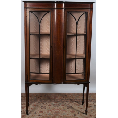 113 - A VINTAGE MAHOGANY AND SATINWOOD INLAID CHINA DISPLAY CABINET of rectangular bowed outline the shape... 