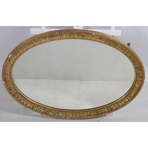 42 - A CONTINENTAL GILTWOOD AND GESSO MIRROR the oval bevelled glass plate within a foliate and beadwork ... 