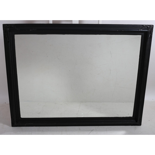 45 - AN EBONISED FRAME MIRROR the rectangular bevel glass plate with stylised foliate and flowerhead moul... 