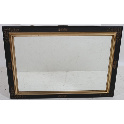 49 - A CONTEMPORARY EBONISED AND GILT FRAME MIRROR the rectangular beveled glass plate with a gilt slip w... 