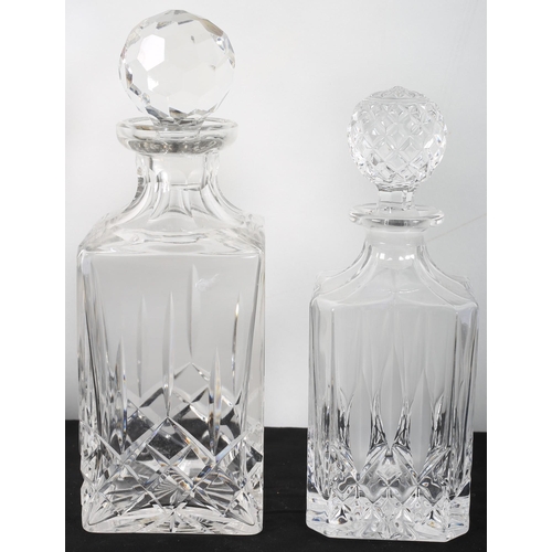 561 - A CUT CRYSTAL DECANTER of square form with stopper together with a similar example (2)