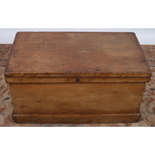 58 - A VINTAGE PINE TRUNK OF RECTANGULAR OUTLINE the hinged lid containing open compartments with two sho... 