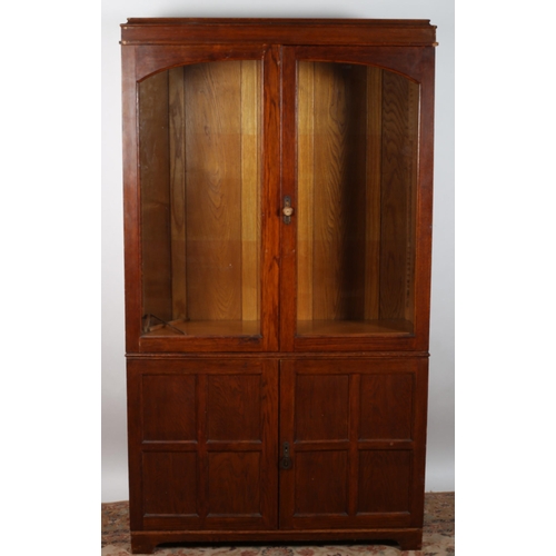 62 - A VINTAGE OAK DISPLAY CABINET the moulded cornice above a pair of glazed doors 
containing adjustabl... 