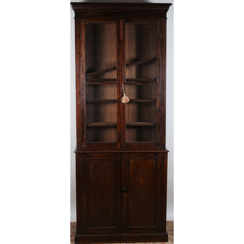 74 - A GEORGIAN DESIGN MAHOGANY BOOKCASE the moulded cornice above a pair of glazed doors containing adju... 