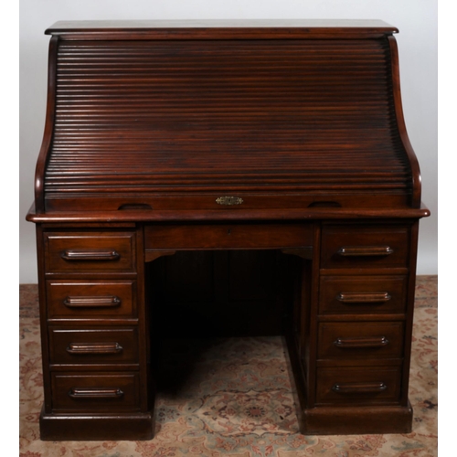 78 - A VINTAGE MAHOGANY ROLLTOP DESK the rectangular top above a tamber shutter containing a pigeon holes... 