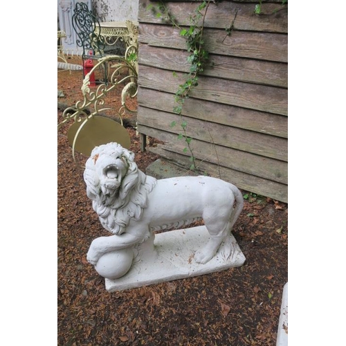 801 - A PAIR OF COMPOSITION STONE FIGURES each modelled as a lion shown standing with one foot raised on a... 