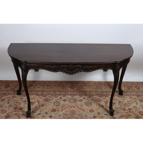 93 - A MAHOGANY SIDE TABLE of rectangular bowed outline the shaped top with shell and foliate carved frie... 