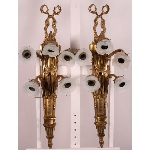 493 - A PAIR OF CONTINENTAL GILT BRASS AND FROSTED GLASS FIVE LIGHT WALL LIGHTS each with an armorial and ... 